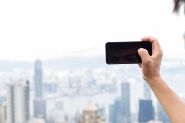 hareket eden telefon ile cityscape arka plan olarak tutan el
