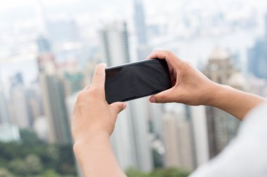 hareket eden telefon ile cityscape arka plan olarak tutan el