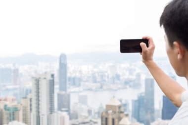 hareket eden telefon ile cityscape arka plan olarak tutan el