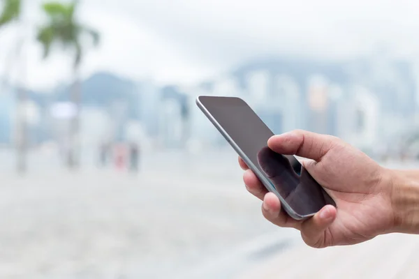 Hand met mobiele telefoon op straat — Stockfoto