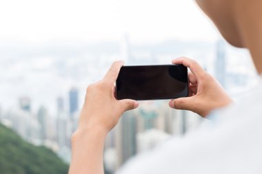 hareket eden telefon ile cityscape arka plan olarak tutan el