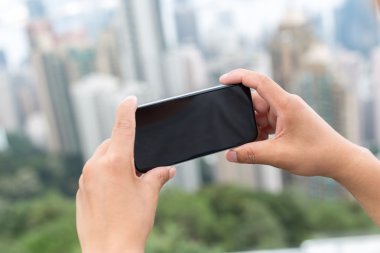 hareket eden telefon ile cityscape arka plan olarak tutan el