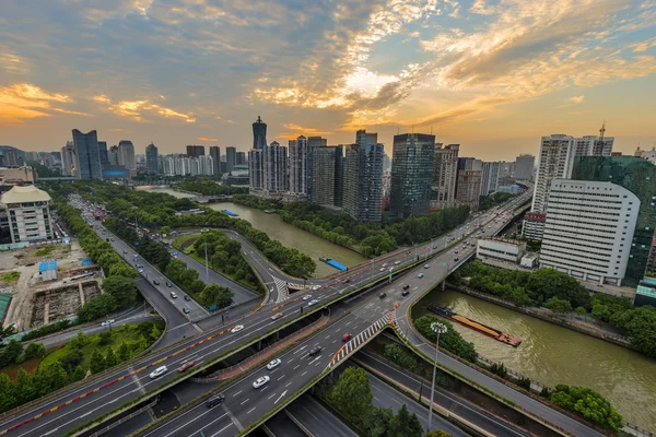 Skyline and road intersection at sunset — Stock Photo, Image