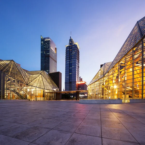 Verlichte modern gebouw buitenkant en lege street — Stockfoto