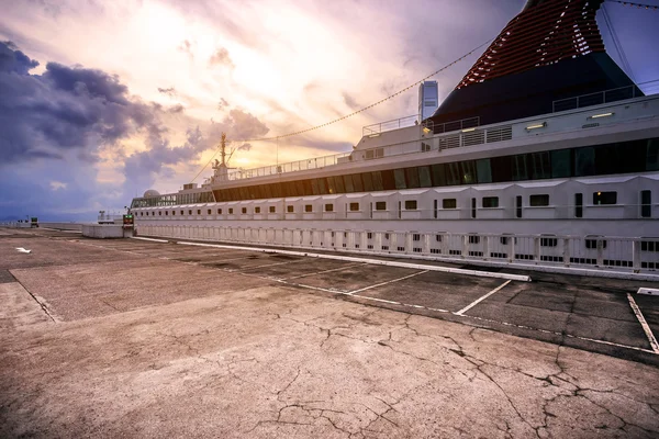 Krydstogtskib og tom dok ved solnedgang - Stock-foto