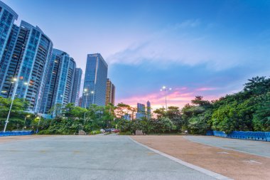 alacakaranlıkta sokak lambaları ile modern bir şehir gökdelenler