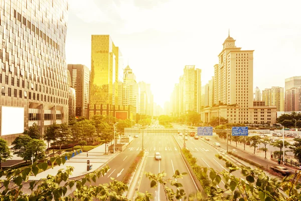 Calle moderna de la ciudad bajo la puesta del sol — Foto de Stock