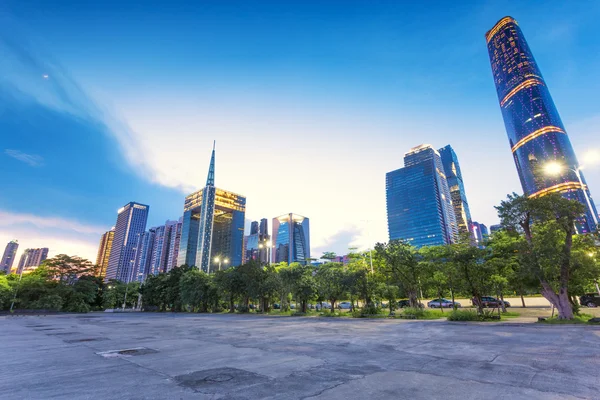 Wolkenkrabbers van een moderne stad in de schemering met lantaarnpalen — Stockfoto