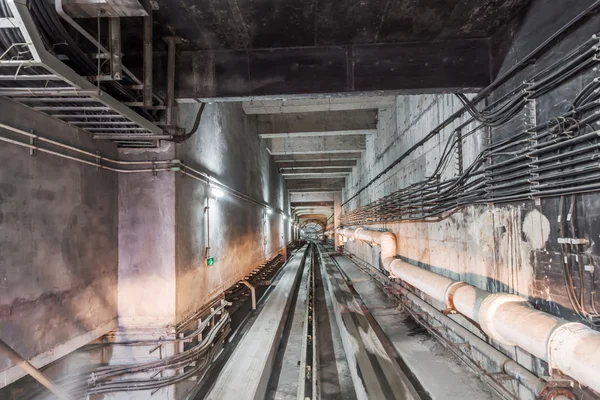 Tubos que atravessam um túnel subterrâneo — Fotografia de Stock