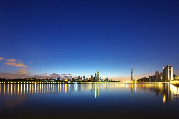 Wolkenkrabbers in de buurt van de rivier in de nacht — Stockfoto