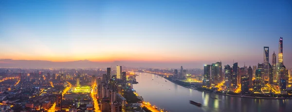 Wolkenkrabbers van de stad in China rond een rivier in de schemering — Stockfoto