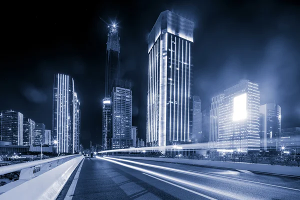 Aszfalt út közelében felhőkarcolók éjjel — Stock Fotó