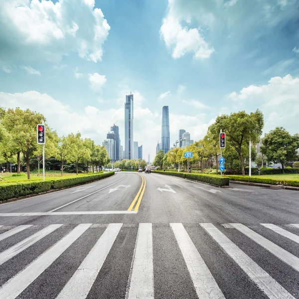 Empty road with zebra crossing and skyscrapers — Stock Photo, Image