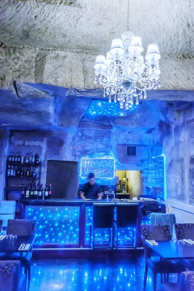 Barman dans un bar entouré de bouteilles de vin — Photo