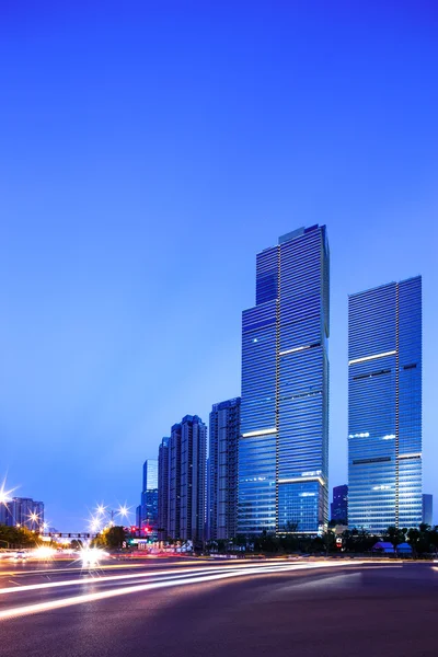 Asphalt road near skyscrapers at night — Stock Photo, Image