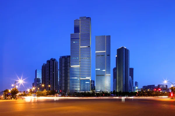 Asphalt road near skyscrapers at night — Stock Photo, Image