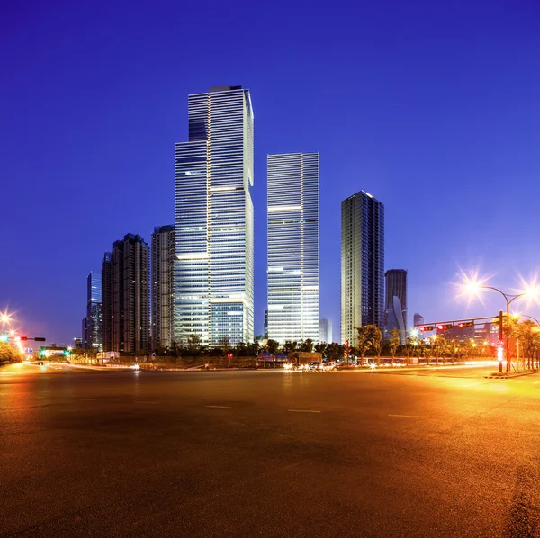 Asphalt road near skyscrapers at night — Stock Photo, Image