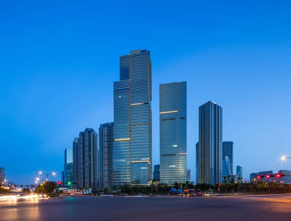 Asphalt road near skyscrapers at night — Stock Photo, Image