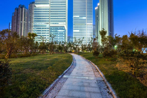 Caminho a pé em um parque perto do arranha-céu — Fotografia de Stock