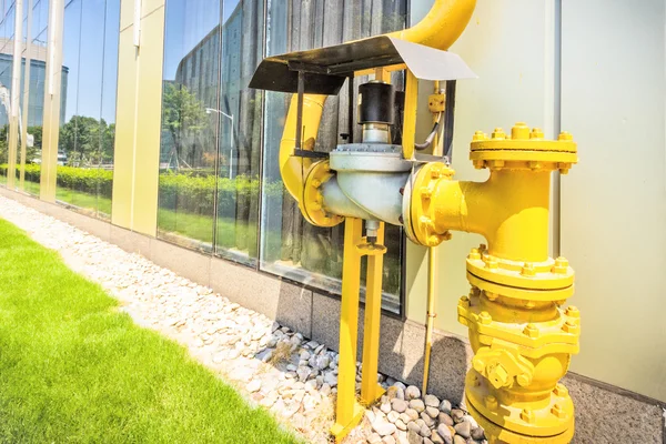 Waterpompen in de buurt van groene pad in de hoek — Stockfoto