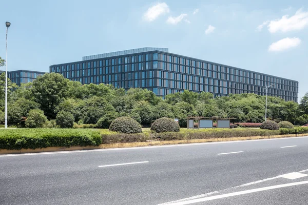 Modernes Bürogebäude mit leerer Straße davor — Stockfoto