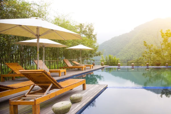 Umbrella chair in hotel pool resort — Stock Photo, Image