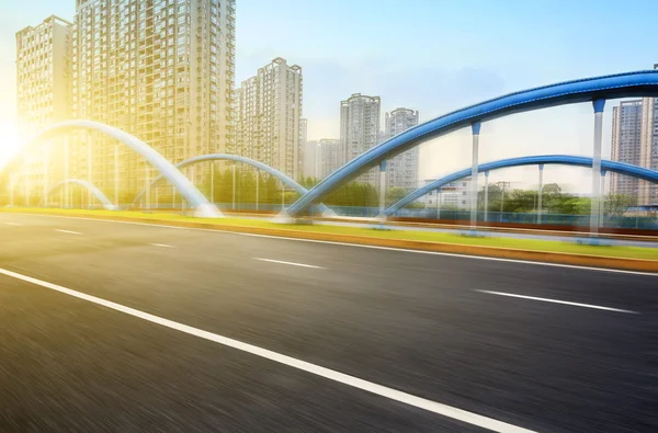 Empty road with buildings at sunset — Stock Photo, Image