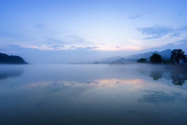 Jezero, hill a reflexe v mlze — Stock fotografie