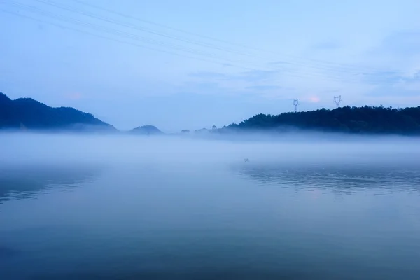 Lago no nevoeiro no céu azul — Fotografia de Stock