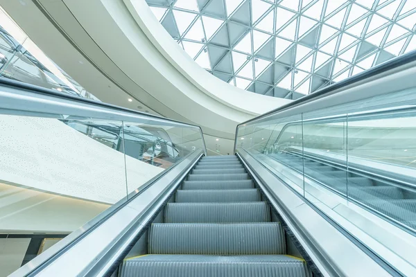 Techo abstracto y escaleras mecánicas en el pasillo del centro comercial — Foto de Stock