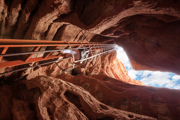 top of cave with iron ladder in red sandstone