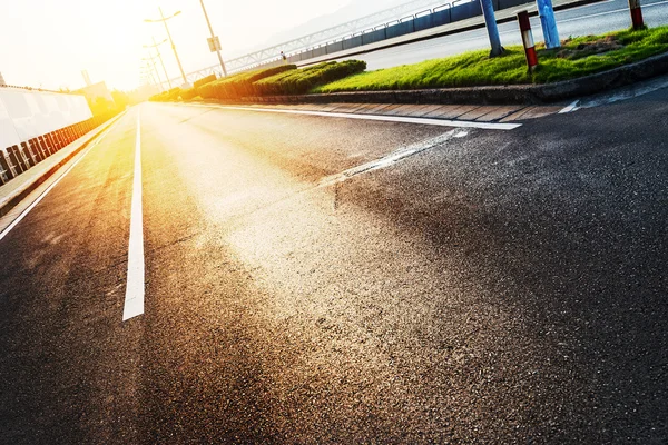 Empty asphalt road by modern buildings — Stock Photo, Image