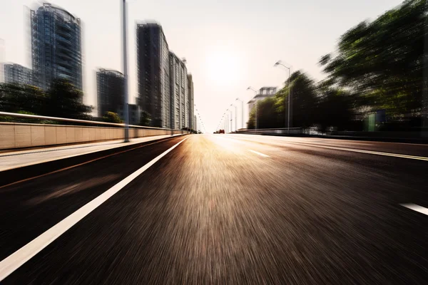 Asfalt yol gündoğumu zaman modern şehir için — Stok fotoğraf