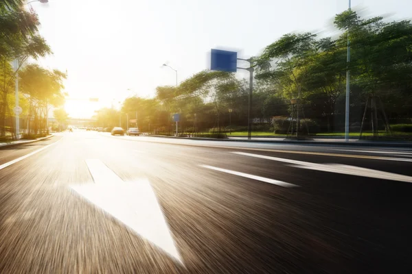 Sunlight and empty asphalt road with traffic sign — Stock Photo, Image