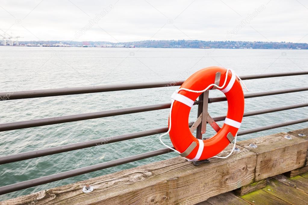 orange buoy on railing by the sea