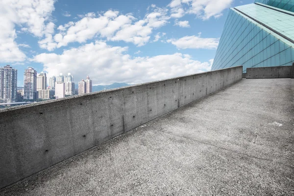 Skyline e caminho vazio por construção — Fotografia de Stock