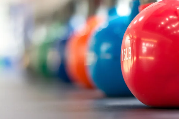 Pesas de colores en el gimnasio o club deportivo —  Fotos de Stock