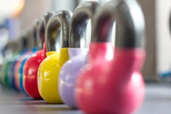 Pesas de colores en el gimnasio o club deportivo —  Fotos de Stock