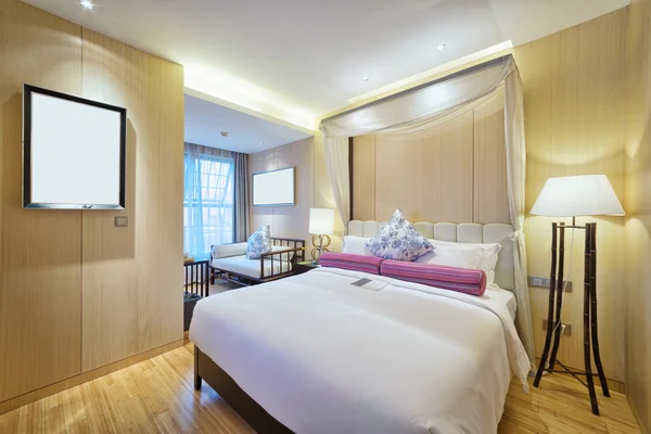 Interiör av moderna sovrum med bekväm säng och soffa — Stockfoto