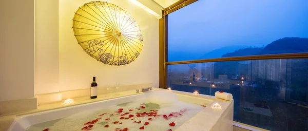 Interior of bathroom with bathtub and rose petals — Stock Photo, Image