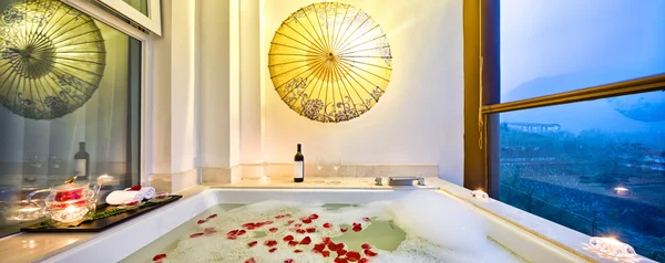 Intérieur de la salle de bain avec baignoire et pétales de rose — Photo