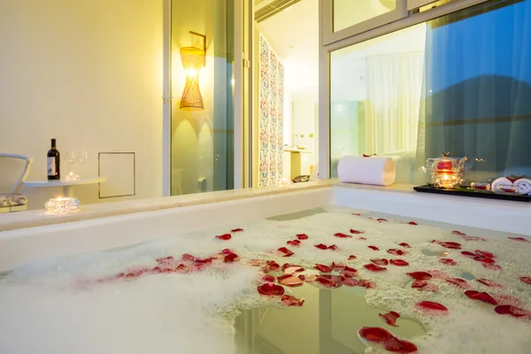 Interior de baño con bañera y pétalos de rosa — Foto de Stock