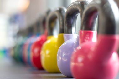 colorful kettlebells lining on table clipart