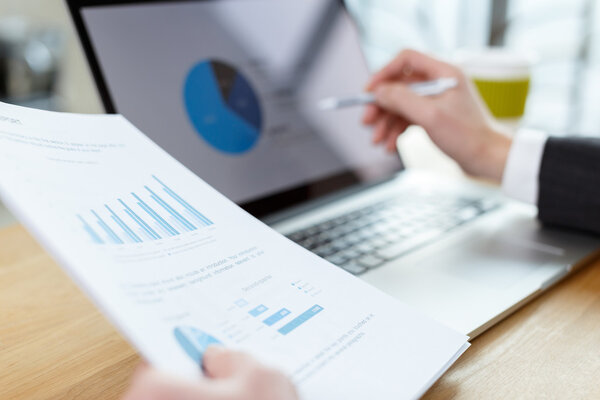 businessman checking financial reports on table