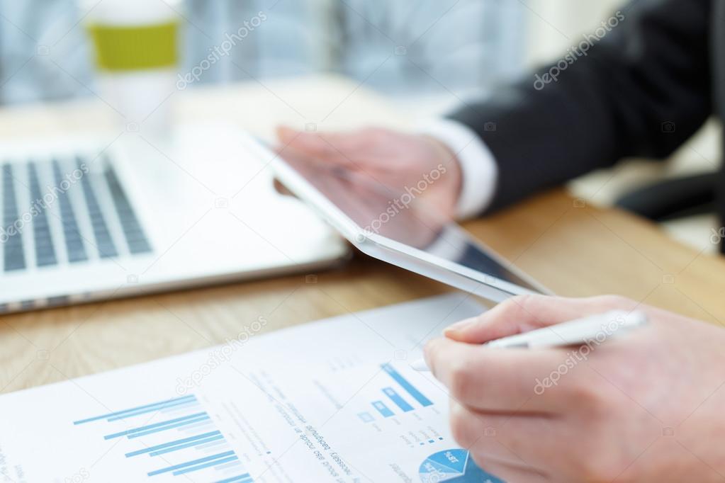 businessman checking financial reports on table