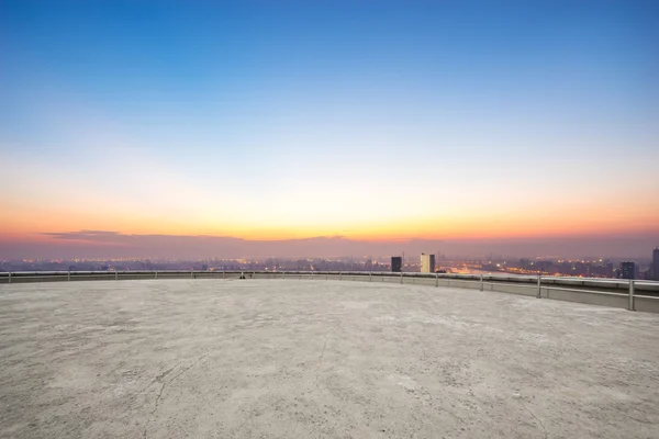 Andar vazio em frente à paisagem urbana ao nascer do sol — Fotografia de Stock