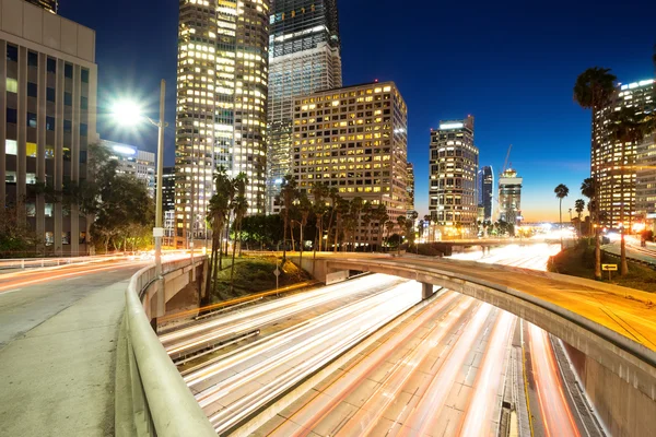Tráfico en carreteras urbanas y edificios por la noche — Foto de Stock
