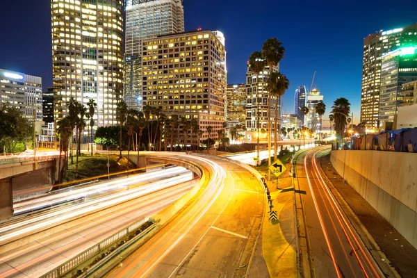 Tráfico en carreteras urbanas y edificios por la noche — Foto de Stock