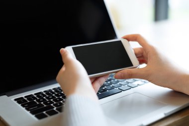 Kafede akıllı telefon kullanan bir kadın.