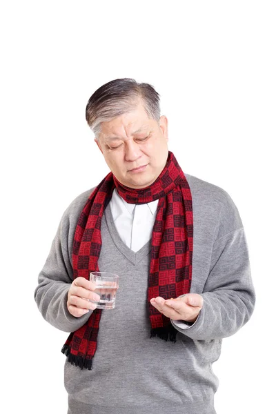 old Asian man taking pills